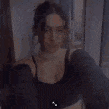 a woman wearing a choker and a sweater is taking a selfie with a camera .