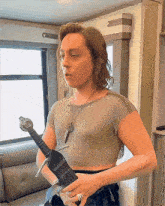 a woman in a crop top is holding a sword in her hands