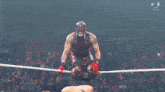 a man in a wrestling ring with the word w on the ground