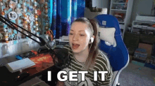a girl is sitting in front of a microphone and says i get it
