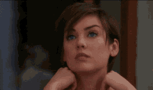 a close up of a woman with short hair making a funny face