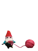a stuffed gnome with skis and a ball of yarn