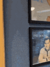 a picture of a man is hanging on a wall next to another picture .