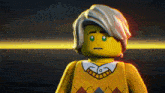 a close up of a lego man wearing a yellow sweater and plaid shirt
