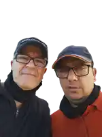 two men wearing glasses and hats are posing for a picture together
