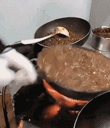 a person is cooking food in a pan on a stove top