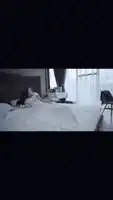 a woman in a white shirt is laying on a bed