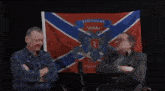 a man sitting in front of a flag that says hob