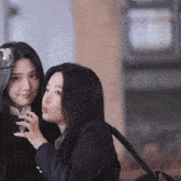 two girls are posing for a picture and one is wearing glasses