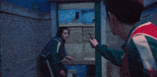 two men are standing next to each other in a dark room .