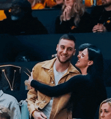 a man and a woman are hugging each other in a crowded room
