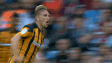 a soccer player wearing a yellow and black striped jersey with sky sports written on it