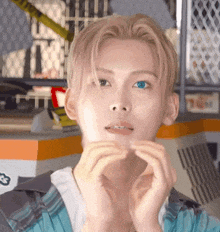 a young man with blonde hair and blue eyes is making a face