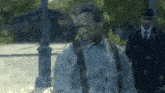 a man in a suit and suspenders is walking down a street