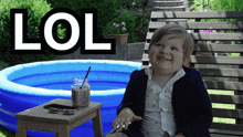 a little boy is sitting in front of an inflatable pool with the word lol written above him