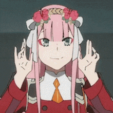 a girl with long pink hair and a flower crown on her head is making a peace sign .