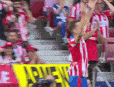 a crowd of people in a stadium with a yellow sign that says ' atletico madrid '