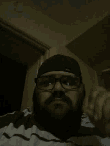 a man with glasses and a beard looks down at something