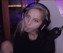 a woman wearing headphones is sticking her tongue out while making a funny face .