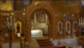 a group of people standing in front of a church altar with icons on the wall