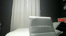 a bedroom with a bed and a chair in the foreground