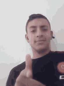 a young man wearing a headset is giving a thumbs up .
