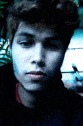 a close up of a young man 's face with a blurred background
