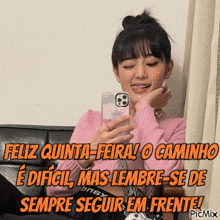a woman in a pink sweater is taking a picture of herself with a caption that says feliz quinta-feira