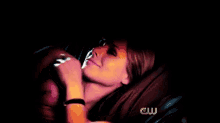 a woman laying on a bed with a cw logo on the bottom right