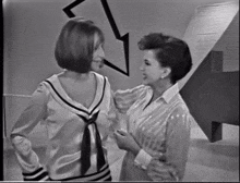 two women are standing next to each other and talking