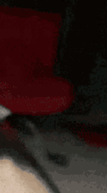 a blurred image of a person 's face with a red and black background