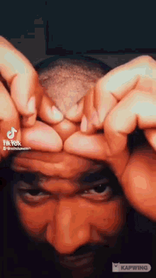 a man is making a funny face with his hands .