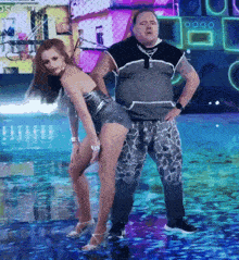 a man and a woman are dancing on a stage and the man is wearing a black shirt with the letter o on it