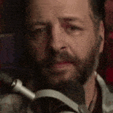 a man with a beard is wearing headphones in front of a microphone .