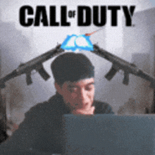 a man is sitting in front of a laptop with a call of duty logo on the top