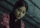 a woman with a scarf around her neck wipes her eyes with her hand