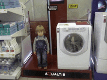 a little boy stands in front of a hotpoint washing machine