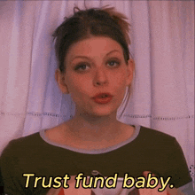 a woman in a green shirt says " trust fund baby " in yellow letters