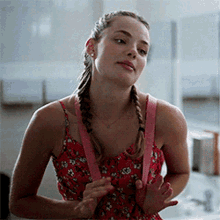 a woman wearing a red dress and pink suspenders