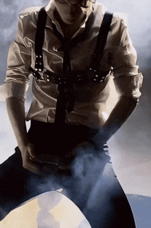 a man wearing suspenders and a tie is kneeling down with his pants down .
