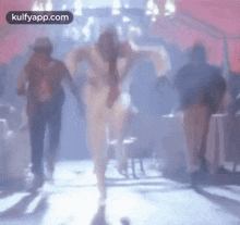 a blurry picture of a man dancing on a stage in a room .