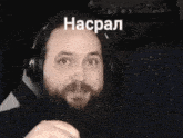 a man with a beard is wearing headphones and the word haspal is on his face .