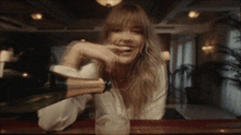 a woman is pouring champagne into a glass while laughing