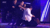 a group of men wearing black staff shirts are fighting