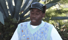 a man wearing a sweater vest with a nike pin on it