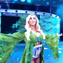 a woman in a green zebra print dress is standing on a stage .