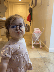 a little girl wearing glasses is making a face
