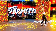 a woman is standing in front of a wall with graffiti on it and holding a microphone .