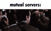 a man in a suit stands in front of a crowd with the words mutual servers below him
