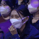 a woman wearing a face mask is smiling in a crowd